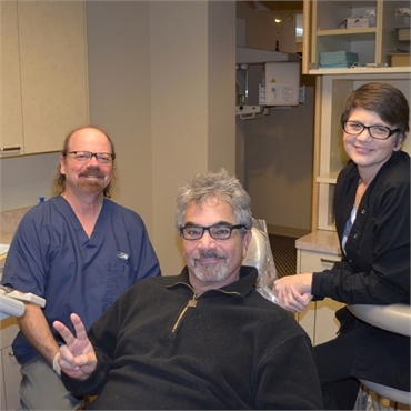 Happy root canal patient with Dr. Hickey and dental hygienist at Sound to Mountain Dental Health Cen