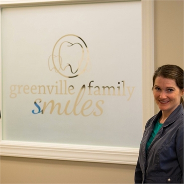 Greenville dentist Anna Goldston standing in front of the signage at Greenville Family Smiles