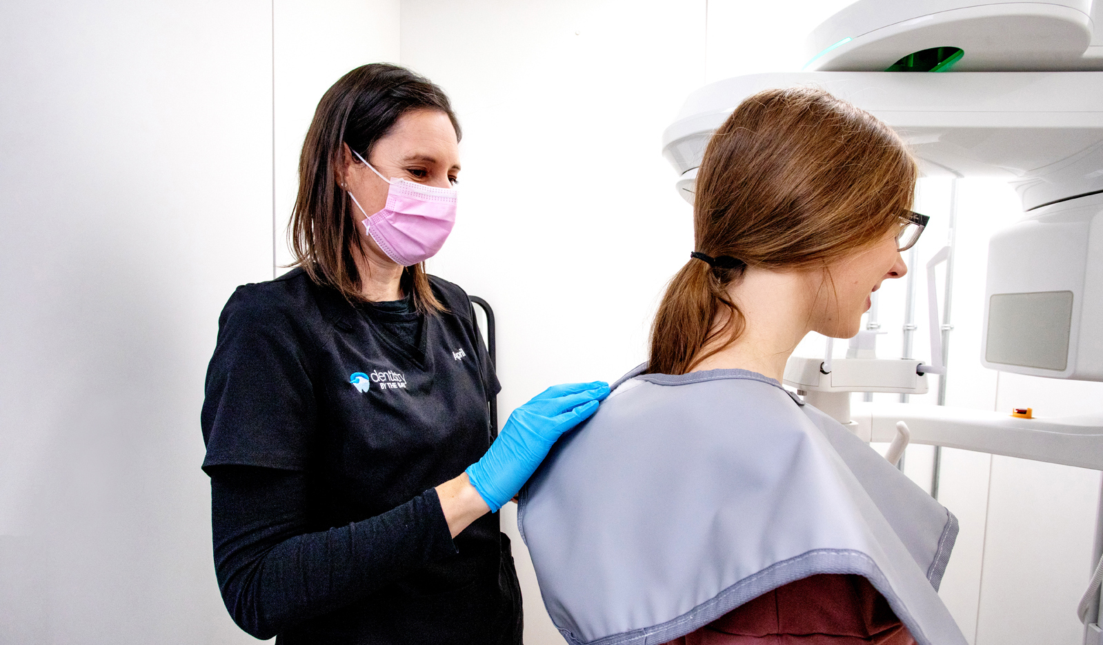 Dental hygienist assisting ClearBraces patient to the 3 D Xray unit at