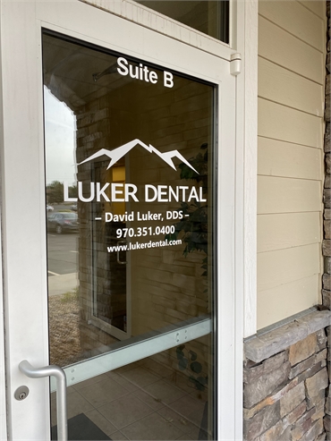 Signage on the glass page on the front door of Greeley dentist Luker Dental