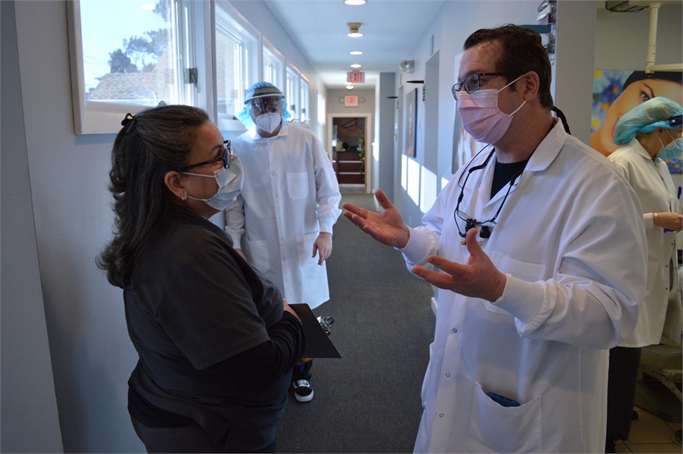 Elizabeth dentist Dr. Joseph Banker discussing day's appointments at Banker Dental Associates