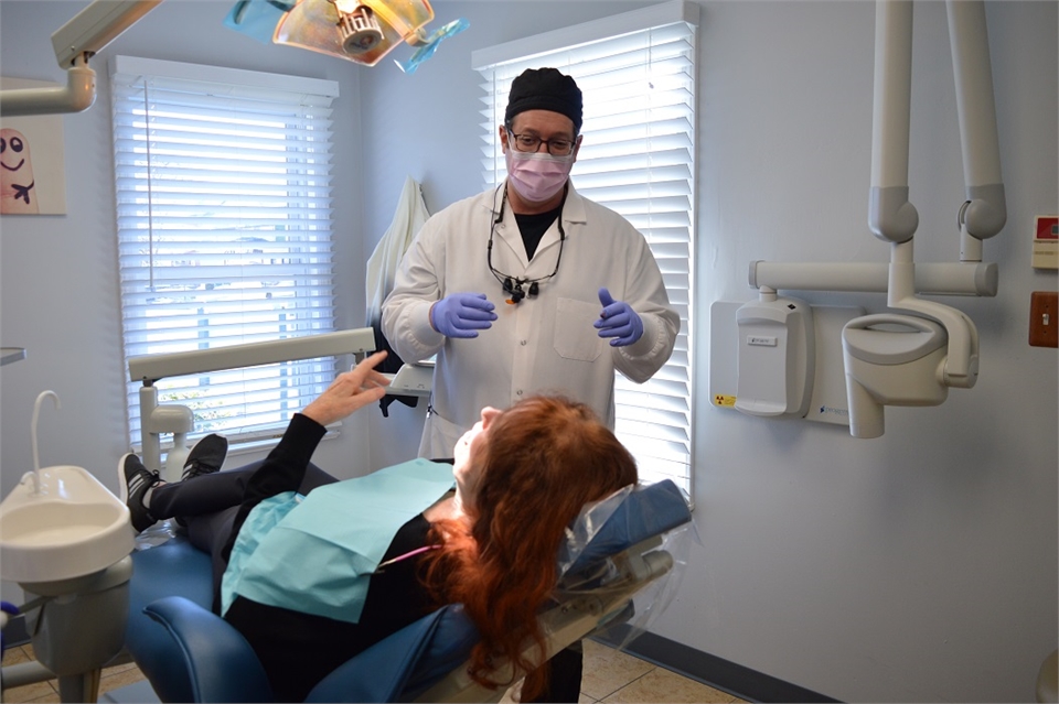 Elizabeth dentist Dr. Joseph Banker interacting with implant supported dentures patient