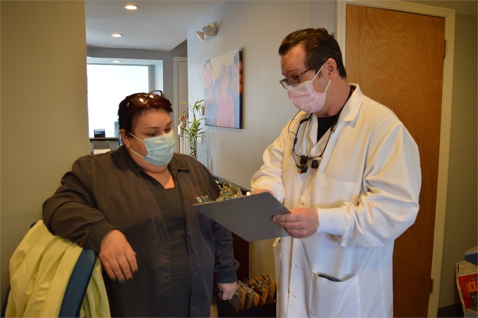 Elizabeth dentist Dr. Joseph Banker discussing appointments with staff at Banker Dental Associates