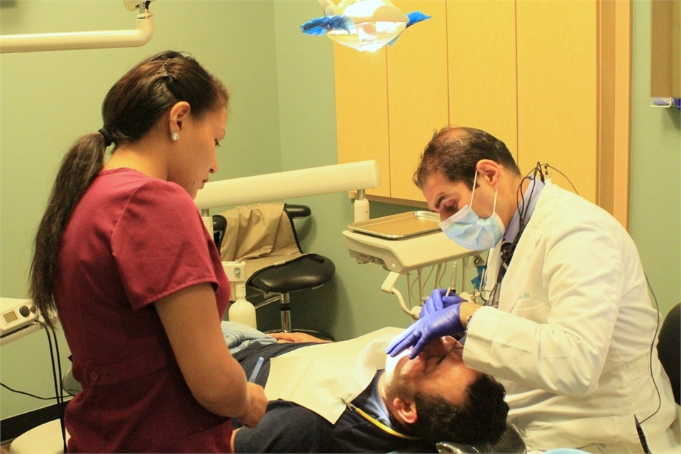 Dr. Uthman performing periodontal procedure