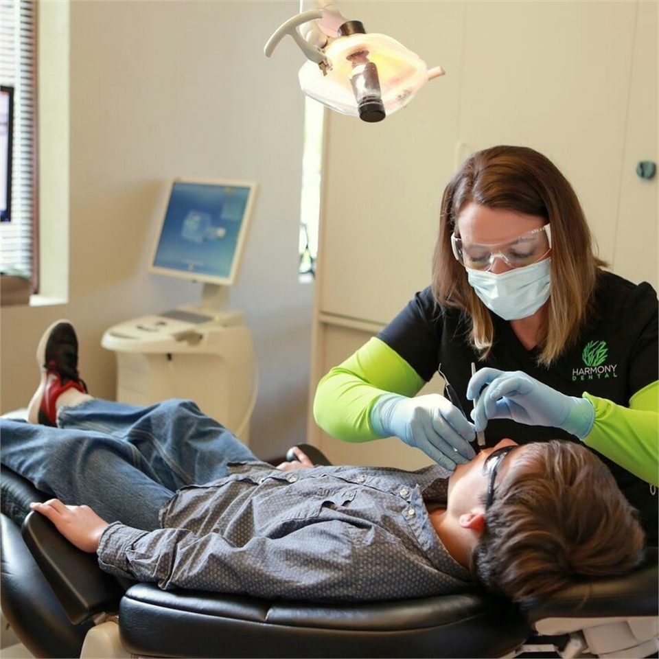 Dental Hygienist at Harmony Dental examining patient