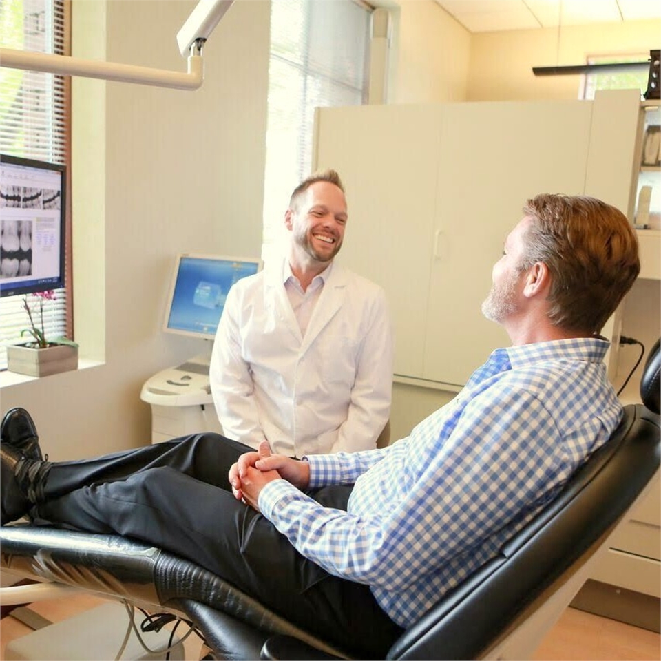 Eugene dentist Dr. Umberger chatting with dental implants patient