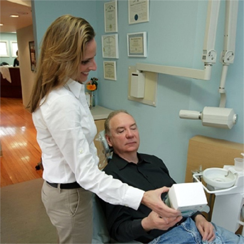 Dental hygienist explains teeth whitening options at the office of Rolando Cibischino DMD
