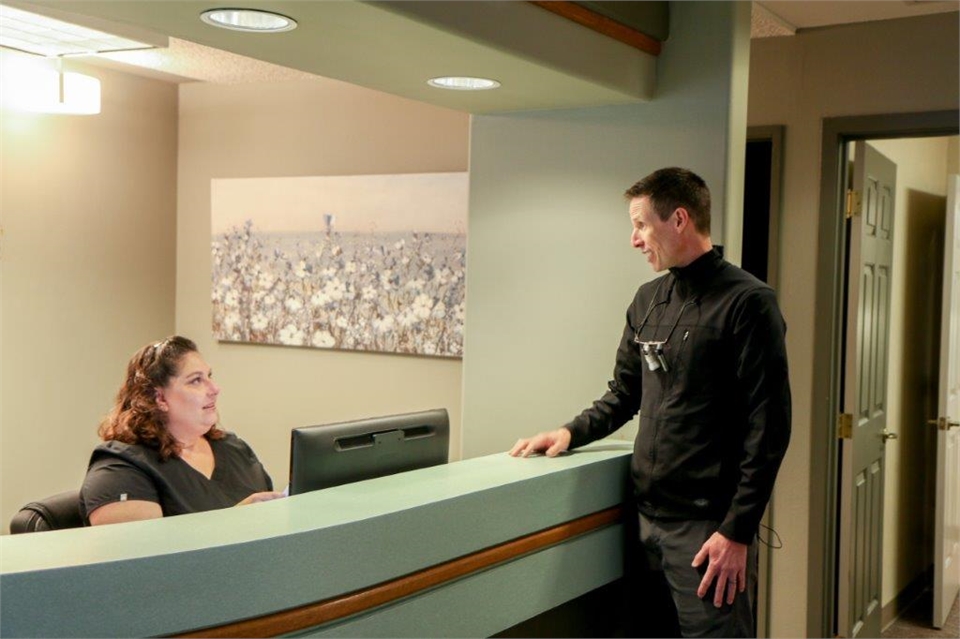 Medford dentist Dr. Warr interacting with reception staff at Elite Dental