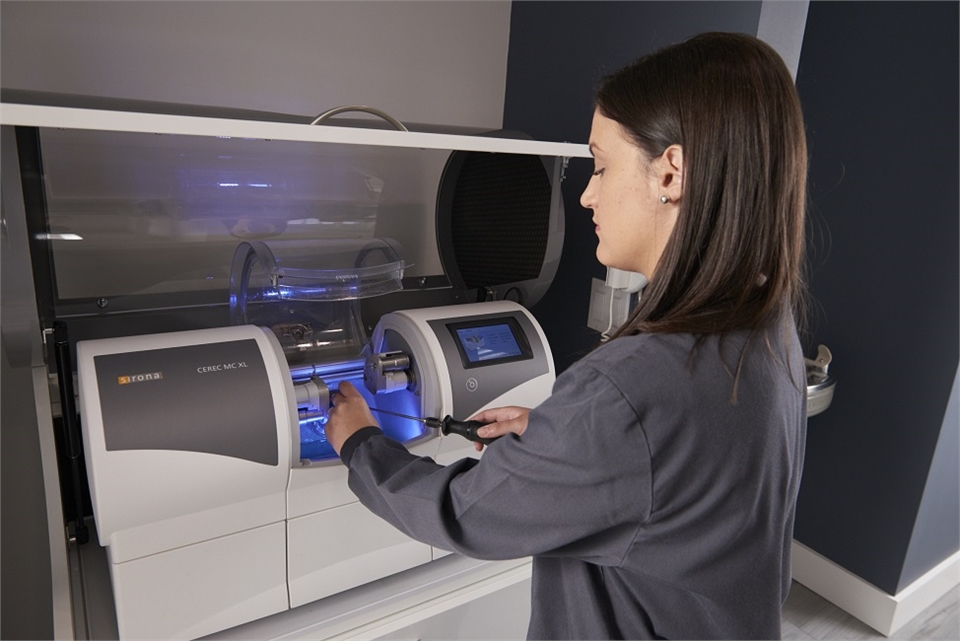 Dental hygienist working on Sirona CEREC MC XL milling machine at Coral Springs dentist Dental Welln