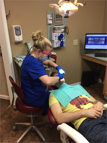 Dental assistant checking mouth of patient at Glenmont Dental