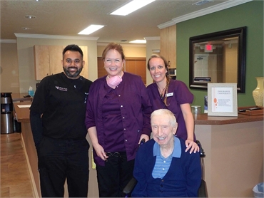 Winter Park dentist Dr Mainak Patel with his team and happy dentures patient at Winter Park Dental
