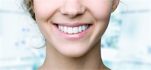 Female with big beautiful teeth smiling at the camera - close-up smile photography