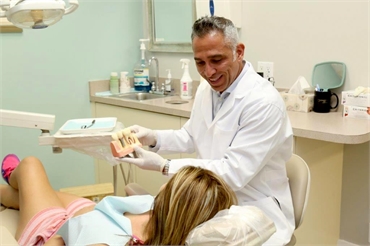 Coral Springs dentist Dr. Diego Azar explaining dental implants to patient at Smile Design Dental of