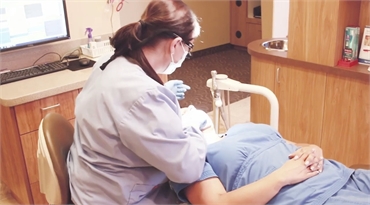 Dental hygienist explaining sedation options to patient at Riggs Family Dental