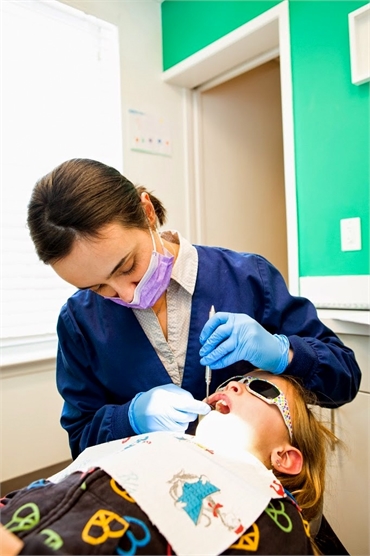 Dr. Christina Ciano of Montgomery Pediatric Dentistry examines the teeh of her patient