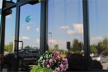 Glass pane with signage on the entrance at Seven Hills Dentistry Dallas GA