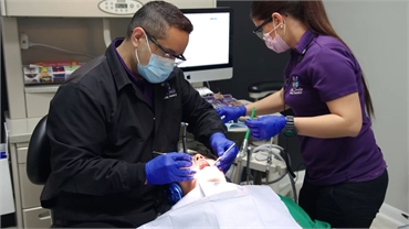 Laredo dentist Dr. John Cavazos fixing dental crown at Ahh Smile Family Dentistry