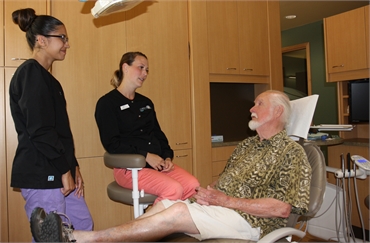Dental hygienists at Current Dental Bainbridge Island explaining root canal treatment with patient