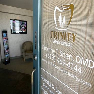 Signage on glass pane on the entrance door at Trinity Family Dental