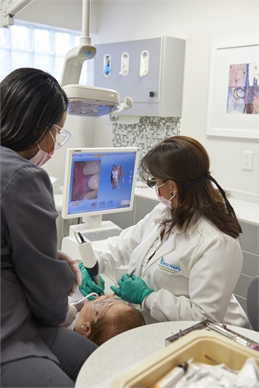 Coral Springs dentist Dr. Daysy Pinero working on CEREC Omnicam intraoral scanner at Dental Wellness