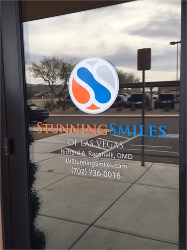 Signage on the glass panel on the entrance door at Stunning Smiles of Las Vegas