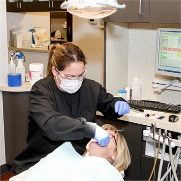 Dental hygienist at Englewood dentist Lincoln Center Dental with dentures patient