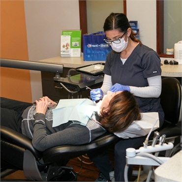 Dental hygienist at Englewood dentist Lincoln Center Dental performing teeth cleaning