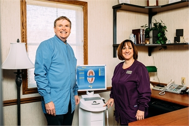 Quad Cities dentists Dr. James and Dr. Carolyn Larsen posing with CEREC Omnicam the most advanced 3D