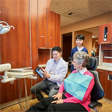 Cosmetic Dentist Doctor Hu and his assistant with an elderly patient at Hu Smiles