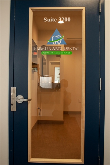 Signage on glass panel on the entrance door at Freehold Township cosmetic dentist Premier Arts Denta