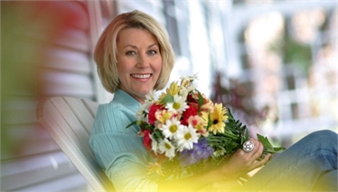 Patient of The Gorman Center for Fine Dentistry North Oaks dentist Kathy smiling with flowers