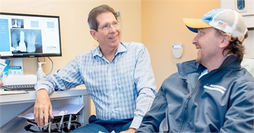 Waldorf dentist Dr Paul B Silberman laughing with a patient at The Silberman Dental Group