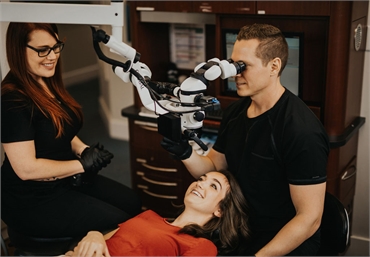 Dr. Michael Webster using dental microscope for root canal procedure at Kelowna Dental Centre