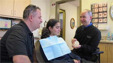 Children dentist Dr. Mark Bancroft explaining a procedure to one of his patients